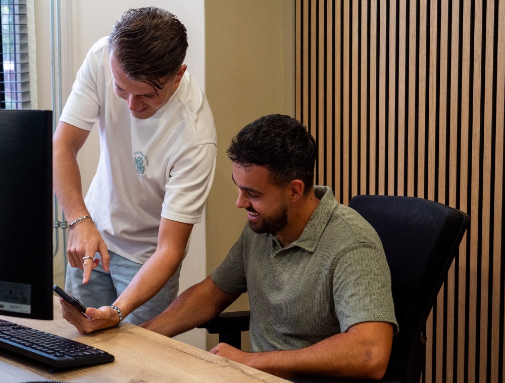 collega's laten elkaar wat zien op de mobiel